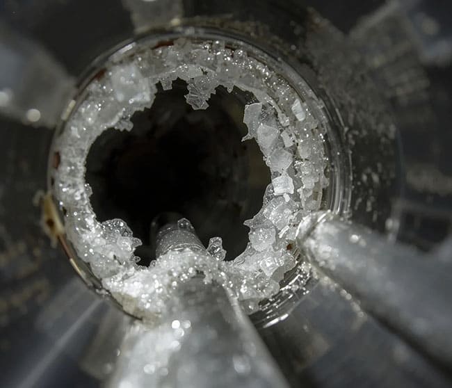 Conductos de cafetera obstruidos por depósitos de cal blanca