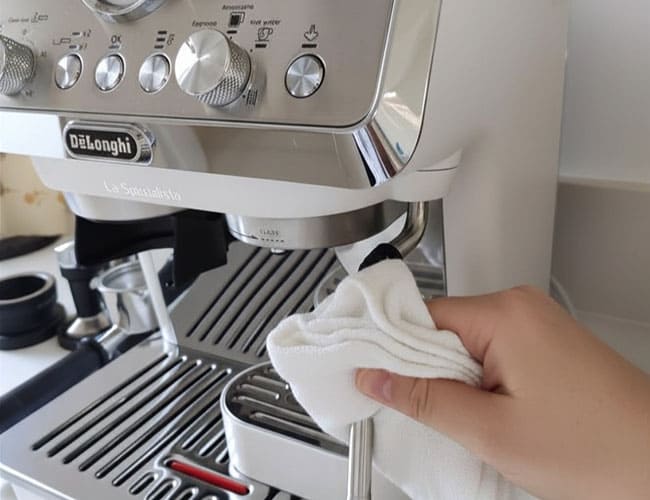Como hacer un capuchino, Limpieza de la lanceta de vapor de una cafetera espresso con paño húmedo y líquido limpiador de leche.