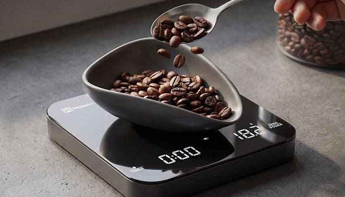 Báscula para café Acaia Lunar colocada bajo el portafiltros de una cafetera manual