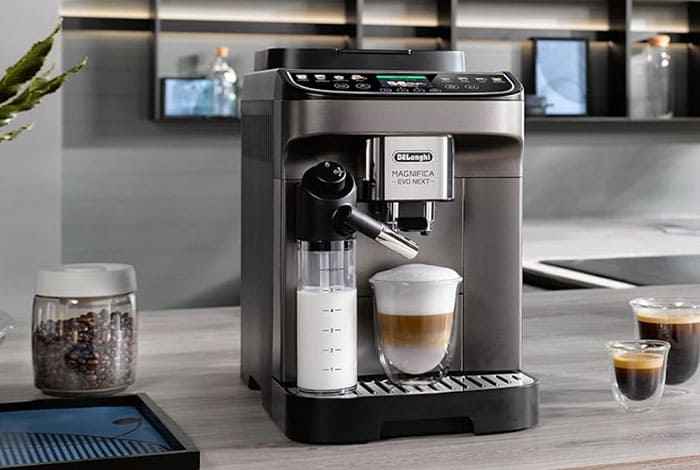 Vista frontal de la cafetera DeLonghi Magnifica Evo sobre la encimera de una cocina moderna.